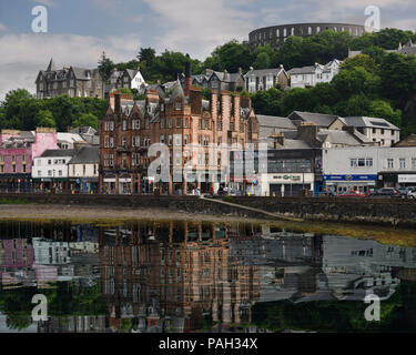 Les bâtiments historiques et la Tour McCaig batterie sur colline avec vue sur le port d'Oban avec de l'eau réflexions dans la baie d'Oban Scotland UK Banque D'Images