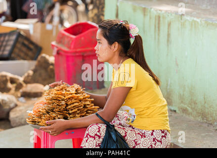BAGAN, MYANMAR - décembre 1, 2016 : une femme vendant des crevettes frites sur une rue de la ville. L'espace de copie pour le texte Banque D'Images