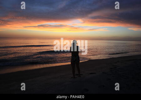 Femme en silhouette de photographier le coucher de soleil sur le golfe du Mexique sur Captiva Island au large de la côte ouest de la Floride, États-Unis. Banque D'Images
