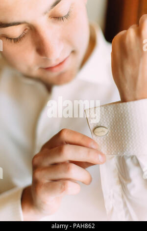 Le marié est à boutonner la chemise avant le mariage. Vue rapprochée. Banque D'Images