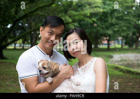 Quel beau couple asiatique avec chien shih tzu Banque D'Images