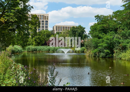 Lac à Clissold Park, Stoke Newington, au nord de Londres au Royaume-Uni, en été, avec de nouveaux appartements en arrière-plan Banque D'Images