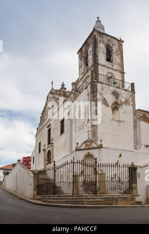 Weathered façade d'une église de Sao Sebastiao dans la ville portugaise de Lagos, situé sur une colline. La porte fermée. Ciel nuageux. Lagos, Algarve, Portugal. Banque D'Images