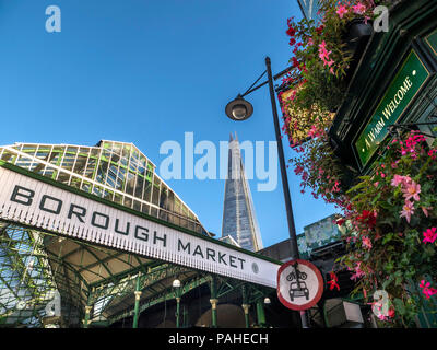 Fleurs extérieures de la façade du marché d'arrondissement et London Shard avec fleurs « The Market porter Pub » avec panneau « a Warm Welcome » au-dessus de l'entrée. Vue extérieure marché international des produits avec le Shard derrière le pont de Londres Southwark Londres Royaume-Uni Banque D'Images