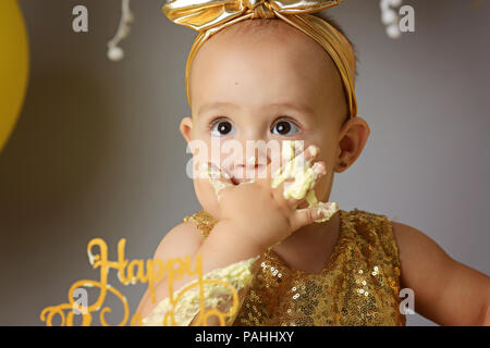 Kid girl eating with ice cream en studio isolé sur gray Banque D'Images