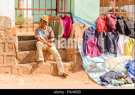 ANTANANARIVO, MADAGASCAR - 30 juin 2011 : l'homme non identifié Madagascar vendent des vêtements au marché et sourit. Les gens souffrent de la pauvreté à Madagascar du Banque D'Images