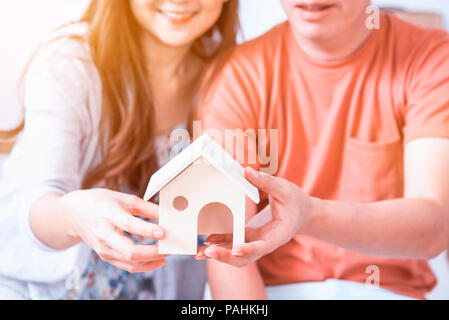 Couple acheter une nouvelle maison. Modèle de maison en bois Holding. Banque D'Images