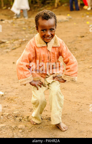 LALIBELA, ÉTHIOPIE - le 28 septembre 2011 : petit garçon éthiopien non identifiés pour l'appareil photo des danses portant chemise rose et un pantalon blanc. Les gens de l'Eth Banque D'Images