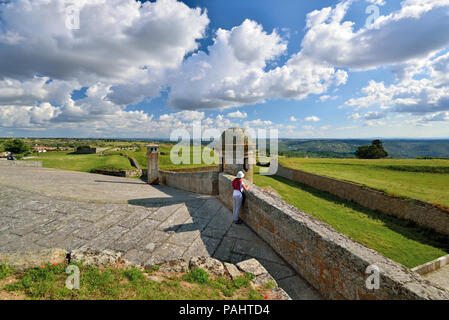 Woman enjoying view de remparts sur une vaste terre verte et dramatique Nuages brûlants Banque D'Images