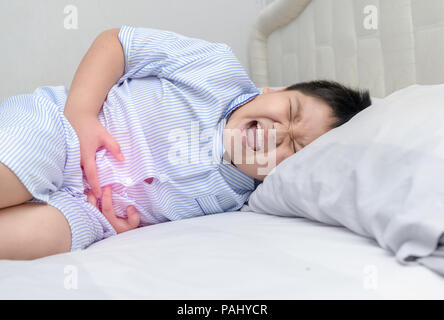 Graisse d'Asie enfant souffrant de stomachache et tache rouge indiquant la localisation de la douleur. concept sain Banque D'Images