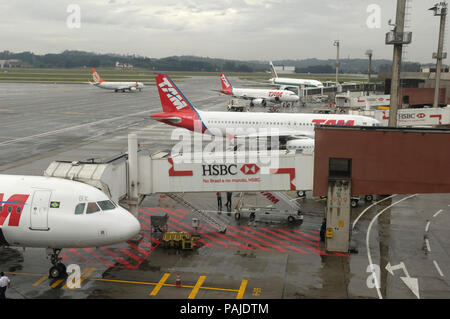 TAM Airbus A320-200 permettront et Alitalia Boeing 777-200ER stationné à la borne et GED 737NG de roulage derrière dans la pluie Banque D'Images