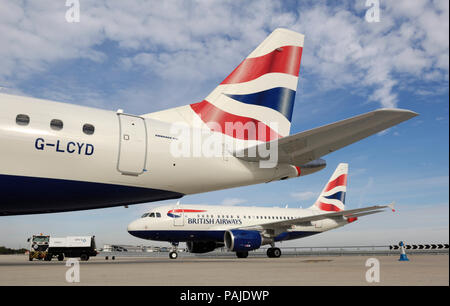 Tail-fin et stabilisateur horizontal de British Airways BA CityFlyer Embraer 170-100STD garé avec British Airways Airbus A318-100 il roulait derrière Banque D'Images