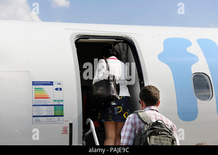 Les passagers ayant des bagages de l'embarquement un Flybe Bombardier DHC-8 Q400 garé Banque D'Images