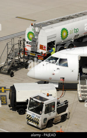 Nez de Scot Airways Dornier Do-328-100 garé avec tracteur, Houchin sol unité de puissance et de l'air BP bowser de ravitaillement au London City Banque D'Images