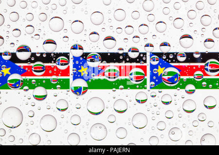 Drapeaux du Soudan du Sud derrière un verre recouvert de gouttes de pluie. Banque D'Images