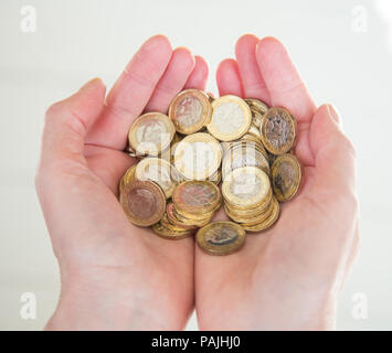 Close-up of a woman's hands holding une pile de pièces livre Banque D'Images