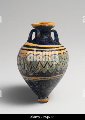 Amphoriskos en verre (flacon de parfum). Culture : le grec, l'Est de la Méditerranée. Dimensions : H. : 3 in. (7,5 cm). Date : fin 6ème-5ème siècle avant J.-C.. Bleu cobalt translucide, avec poignées de même couleur ; sentiers en jaune opaque opaque et bleu turquoise. Profondément vers l'intérieur de la pente-rim ; disque ; cou cylindrique large oblique ; top ; en forme de bouton à base circulaire à fond plat ; deux poignées sangle verticale appliquée à l'épaule, établi et dans, et sous pression sur le cou. Un sentier jaune épais attaché à bord de jante-disque ; un autre sentier jaune épais appliqué sur l'épaule, blessure dans une spirale, puis transformée en une Banque D'Images