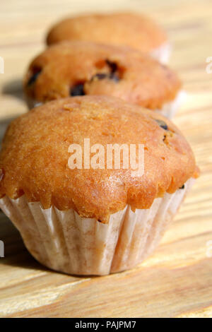 Muffins l'un après l'autre sur un fond de bois Banque D'Images