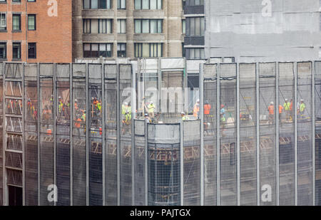 Grand groupe de travailleurs de la construction travaillant sur un étage d'un immeuble de Manhattan, NYC Banque D'Images