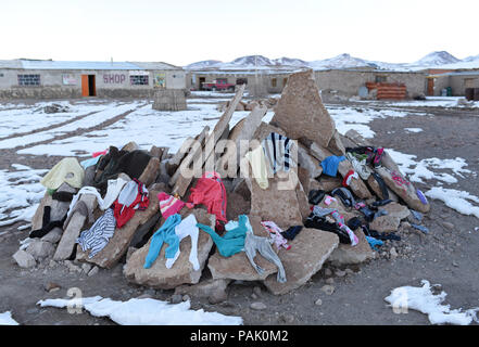 Vêtements lavés d'une famille le séchage sur une pile de débris de ciment dans la petite entente de Huayllajara (sur l'Altiplano, près de la Laguna Colorada), Bolivie Banque D'Images