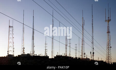 Les antennes relais de communication au coucher du soleil Banque D'Images