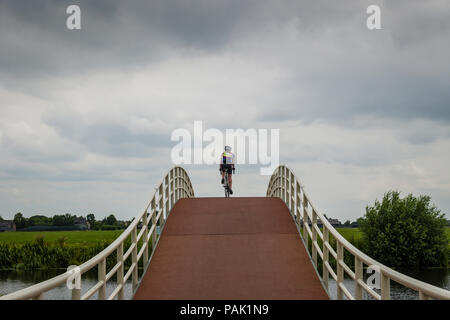 Seule femme cycliste sur le pont sur la route moulin Hollande Banque D'Images