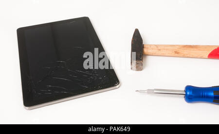 Tablette cassée vitre avec un marteau et un tournevis, suggérant la réparation de garantie sur un fond blanc Banque D'Images