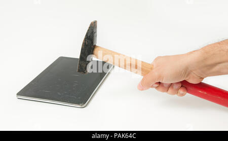 La main d'un homme frappe une tablette avec un écran tactile cassé qui suggère qu'il va le remplacer Banque D'Images