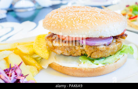 Big tasty burger de poulet avec pommes de terre frites Hamburger frites salade de chou chou des oignons et des tomates dans une vue délicieuse fermer Banque D'Images