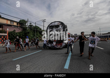 Quezon City, Philippines. 23 juillet, 2018. Tirer sur des manifestants une effigie du Président Rodrigo Duterte comme ils marche vers le Congrès philippin le long de l'Avenue du Commonwealth lors de son troisième discours sur l'état de la Nation (SONA) dans la ville de Quezon, lundi. Le 23 juillet 2018. Divers groupes militants ont protesté contre Duterte, d'avoir manquer à ses promesses telles que mettre fin à la contractualisation, la réduction de la pauvreté et de sa soi-disant guerre contre la drogue, qui a tué des milliers de personnes, principalement les pauvres. Credit : Basilio Sepe/ZUMA/Alamy Fil Live News Banque D'Images