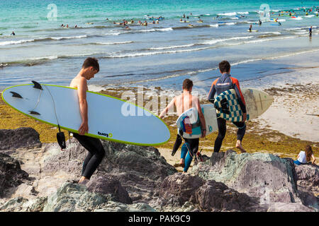 Plage de Polzeath, Cornwall, UK. 23 juillet 2018. Tête de Surfers à la plage par une chaude journée ensoleillée à Polzeath sur la côte Atlantique du nord des Cornouailles Crédit : Mark Richardson/Alamy Live News Banque D'Images