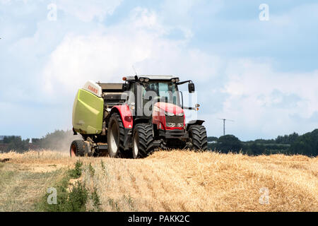 Maidstone, Royaume-Uni. Mardi 24 juillet 2018. Maidstone, Kent, UK. Un champ de maïs est récolté dans une vague de chaleur caniculaire. Un tracteur et de la machine à emballer la paille Photo credit : hmimages/AlamyLive News Banque D'Images