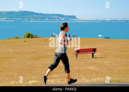 Weymouth. 24 juillet 2018. Une femme déroule le passé, l'herbe brûlée brun donnant sur Portland - Weymouth, Dorset Crédit : Stuart fretwell/Alamy Live News Banque D'Images