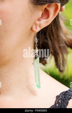 Woman wearing earring cristal quartz naturel Banque D'Images