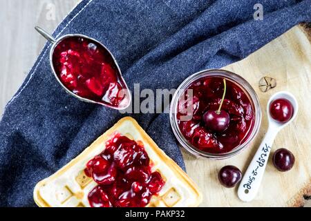 Les gaufres et Confiture de cerises maison sur un fond denim Banque D'Images