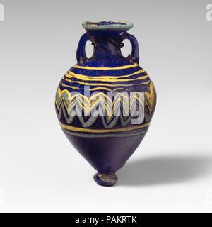 Amphoriskos en verre (flacon de parfum). Culture : le grec, l'Est de la Méditerranée. Dimensions : H. : 3 1/2 in. (8,9 cm). Date : fin 6ème-5ème siècle avant J.-C.. Bleu cobalt translucide, avec poignées de même couleur ; sentiers en jaune opaque opaque et bleu turquoise. L'intérieur de la pente inégale jante-disque ; cou cylindrique spirale avec des marques d'outillage, effilé vers le bas ; large oblique ; top-forme circulaire ; base-bouton avec tiret sur le fond ; deux poignées sangle appliquées à haut de l'épaule, dressé, et emmanché sur le cou. Sentier bleu turquoise attaché à bord de jante-disque ; un sentier jaune appliqué dans un irr Banque D'Images