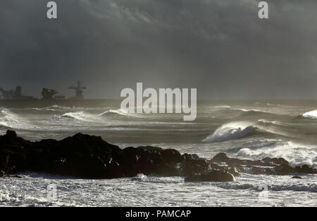 Mur nord du Port de Leixoes, nord du Portugal, dans une soirée de fin d'automne, sous un orage avec un éclairage intéressant filtrés par les nuages et l'humidité Banque D'Images