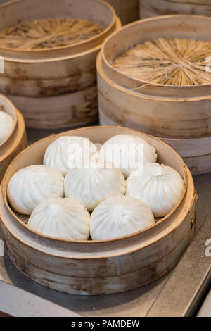 Boulettes de pains traditionnels dim sum vapeur en bambou dans des conteneurs. Banque D'Images