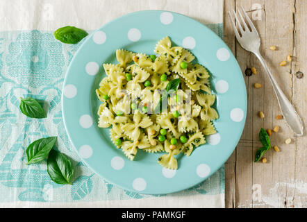 Les Pâtes au pesto, les pois verts et basilic sur une table en bois. De style rustique, selective focus. Banque D'Images