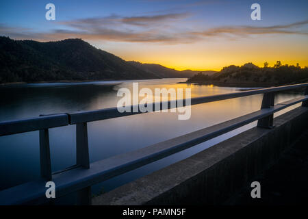 L'exposition à long shot de Don Pedro réservoir, avec effet d'eau lisse et fiery coucher du soleil - Sierra Foothills - Tuolumne County, Californie Banque D'Images