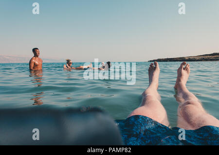 Les touristes se détendre, nager et flotter dans la mer Morte, Israël, qui est tellement salé qu'il est impossible pour un corps humain à couler Banque D'Images