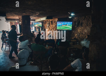 Un groupe d'hommes jordaniens narguilé fumer et regarder l'Argentine jouer la France dans la Coupe du Monde FIFA 2018 dans un bar à Wadi Musa, Jordan Banque D'Images