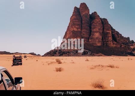 Trucs et astuces de ramassage pleine de touristes en voiture dans un convoi à travers les sables du désert rouge dans le célèbre Parc National de Wadi Rum, Jordanie Banque D'Images