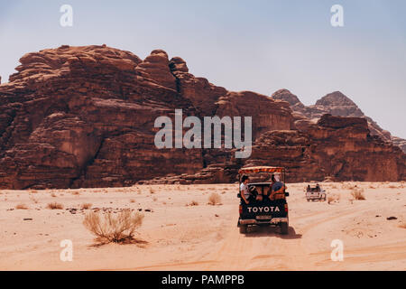 Trucs et astuces de ramassage pleine de touristes en voiture dans un convoi à travers les sables du désert rouge dans le célèbre Parc National de Wadi Rum, Jordanie Banque D'Images