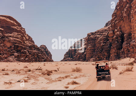 Trucs et astuces de ramassage pleine de touristes en voiture dans un convoi à travers les sables du désert rouge dans le célèbre Parc National de Wadi Rum, Jordanie Banque D'Images