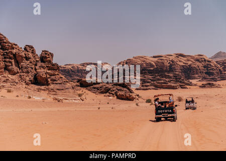 Trucs et astuces de ramassage pleine de touristes en voiture dans un convoi à travers les sables du désert rouge dans le célèbre Parc National de Wadi Rum, Jordanie Banque D'Images