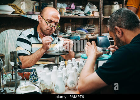 Deux potiers palestiniens donner une couche de peinture décorative pour certains d'argile blanche porcelaine Banque D'Images