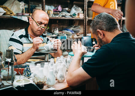 Deux potiers palestiniens donner une couche de peinture décorative pour certains d'argile blanche porcelaine Banque D'Images