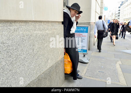 Femme vêtu de noir et portant un sac de Sainsbury's au centre de Londres, Angleterre, Royaume-Uni. Banque D'Images