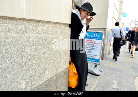 Femme vêtu de noir et portant un sac de Sainsbury's au centre de Londres, Angleterre, Royaume-Uni. Banque D'Images